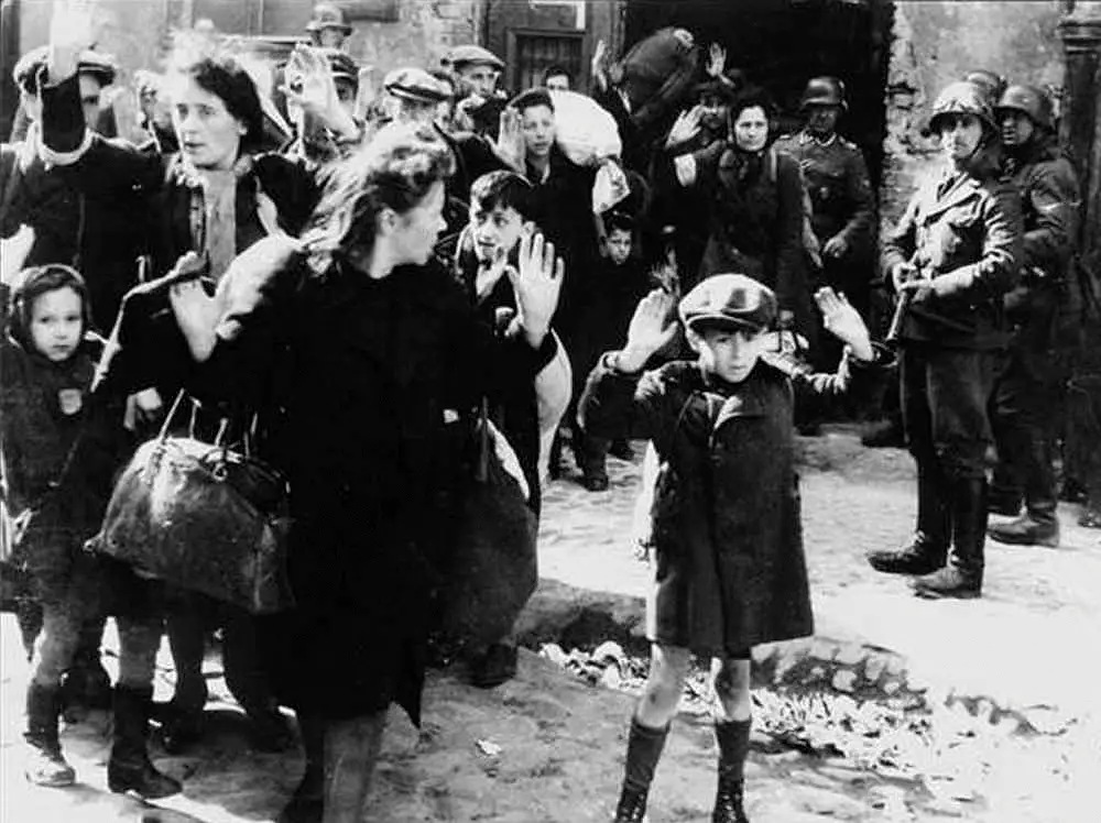 Niemieccy żołnierze SS w czasie powstania siłą wyprowadzają żydowską ludność cywilną z warszawskiego getta, maj 1943 r.
